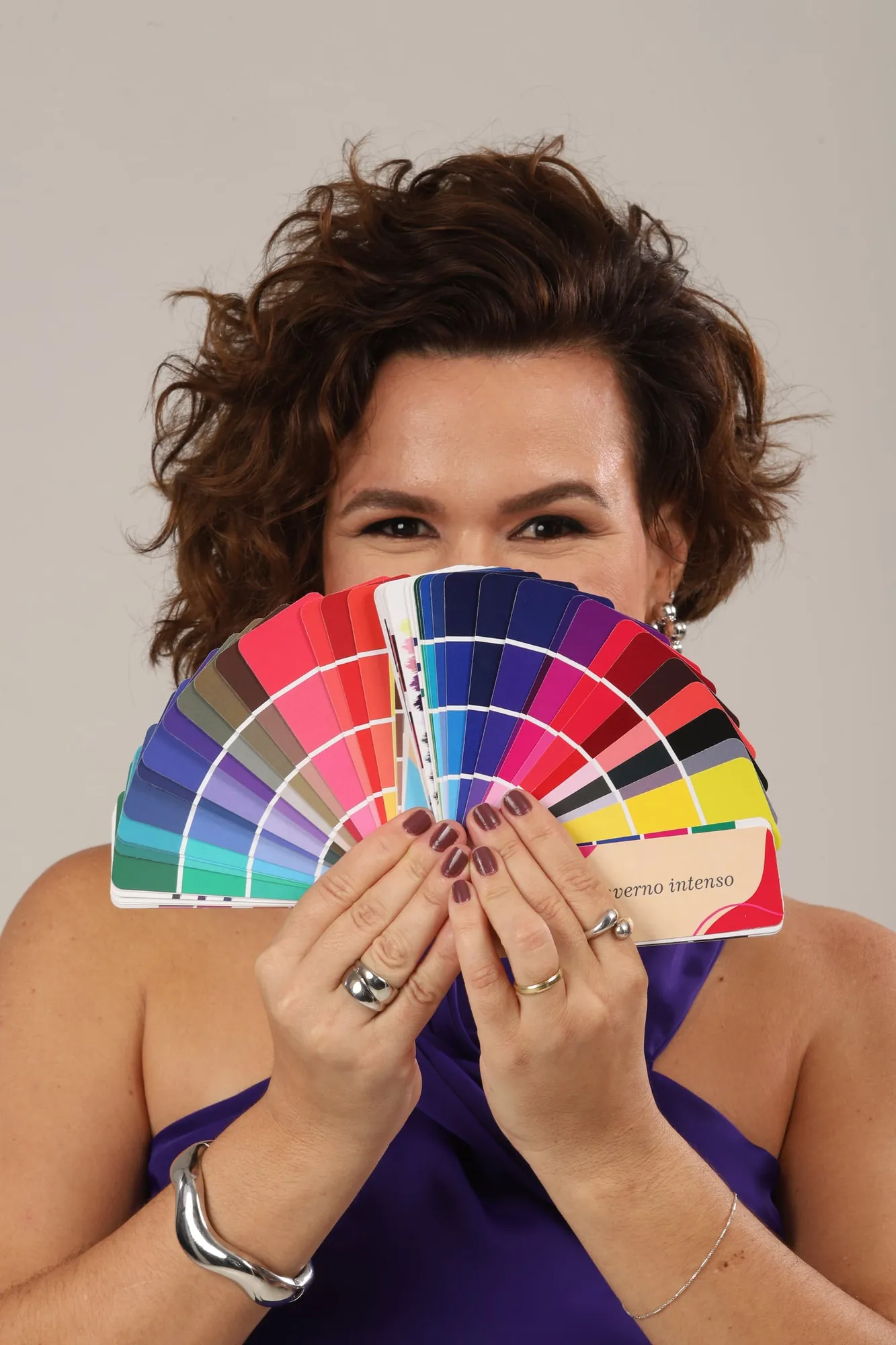 Laura Mareom na análise de coloração pessoal, com o leque de cores diante do rosto