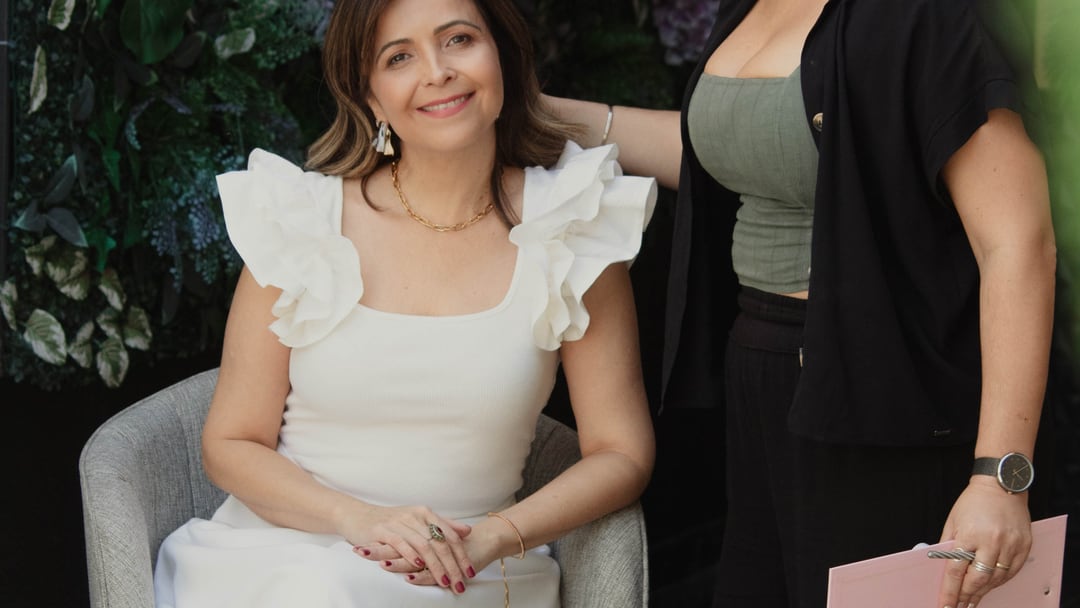 Atendimento de consultoria de imagem: cliente sentada e Laura Mareom ao lado, com o leque de cores